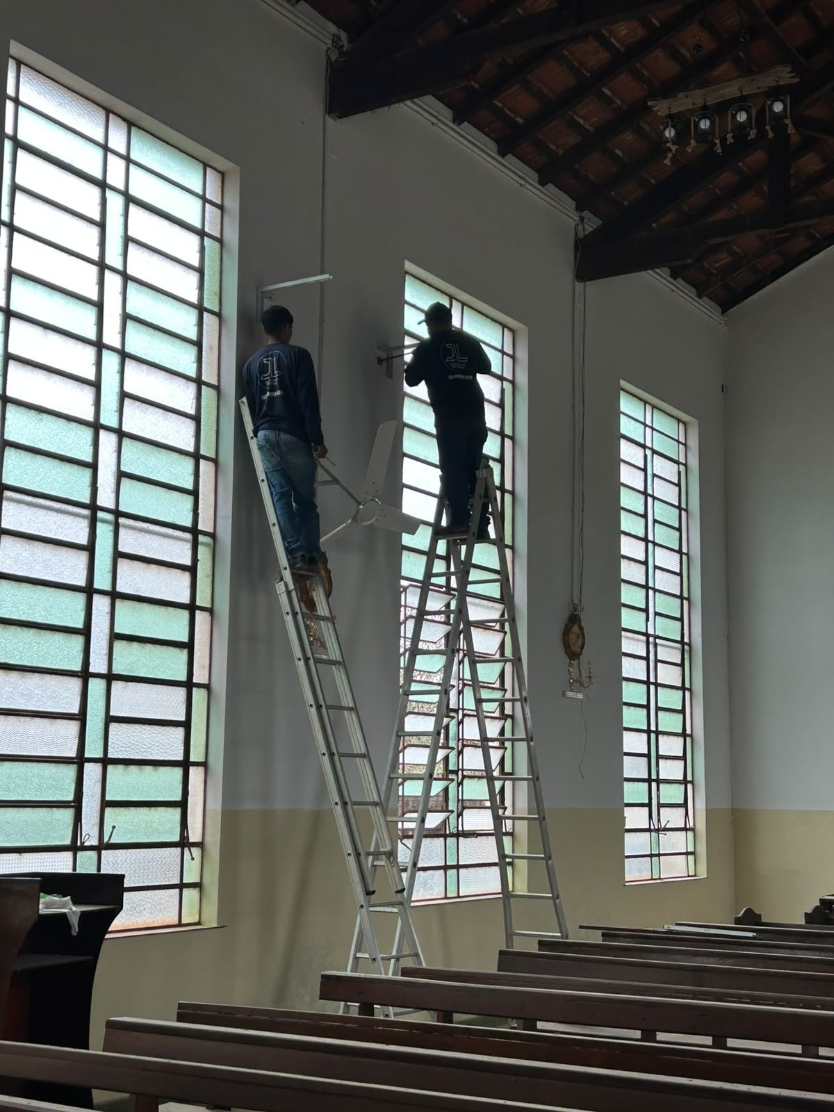 Equipe da JL Higienização & Refrigeração instalando climatização em ambiente comercial